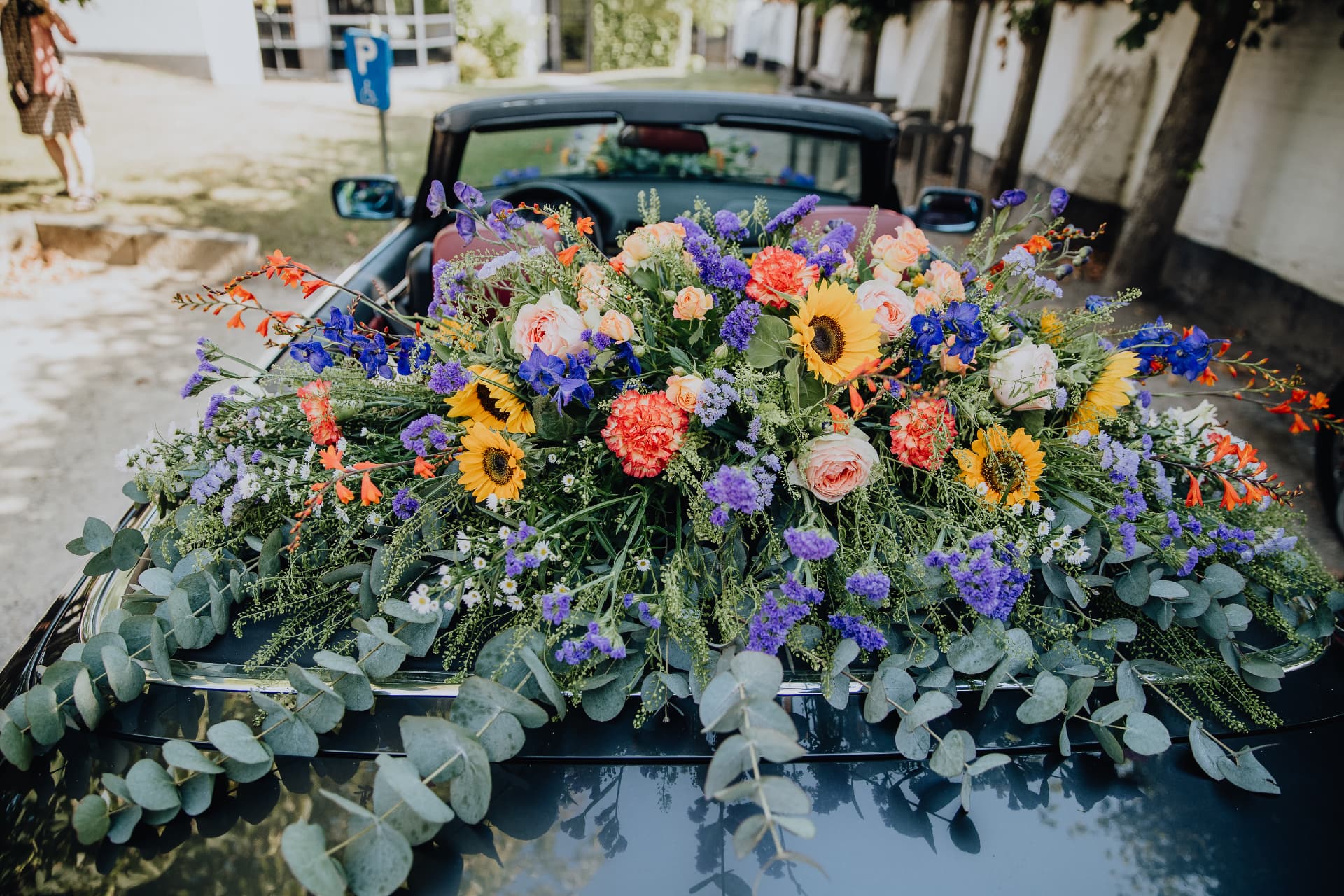 Trouwauto versierd met zonnebloemen en veldbloemen