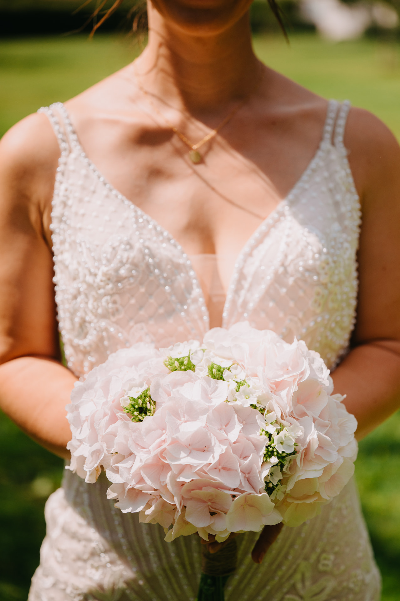 Bruid met zachtroze hydrangea bruidsboeket