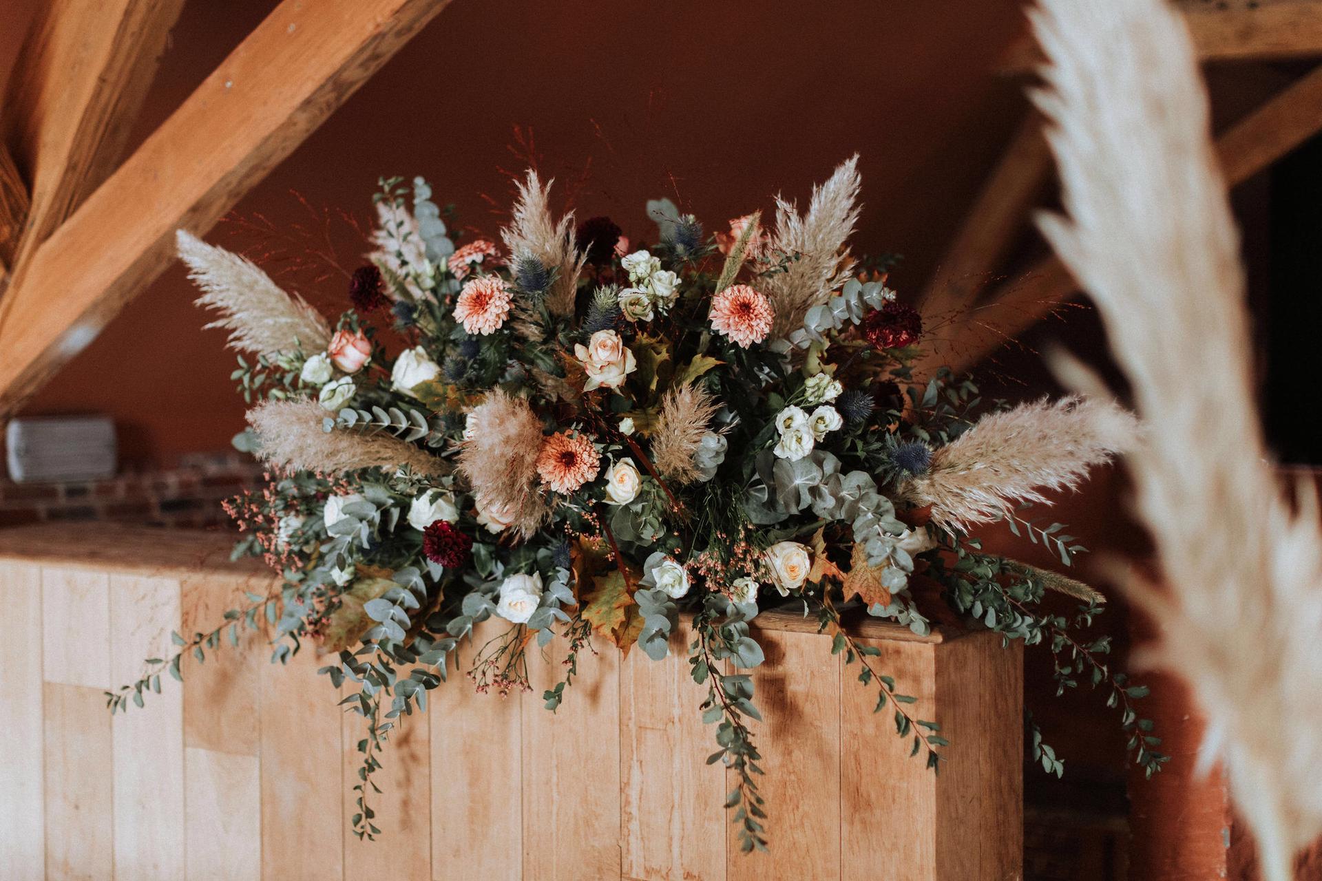 Herfstig bloemstuk met pampas en eucalyptus in een schuur